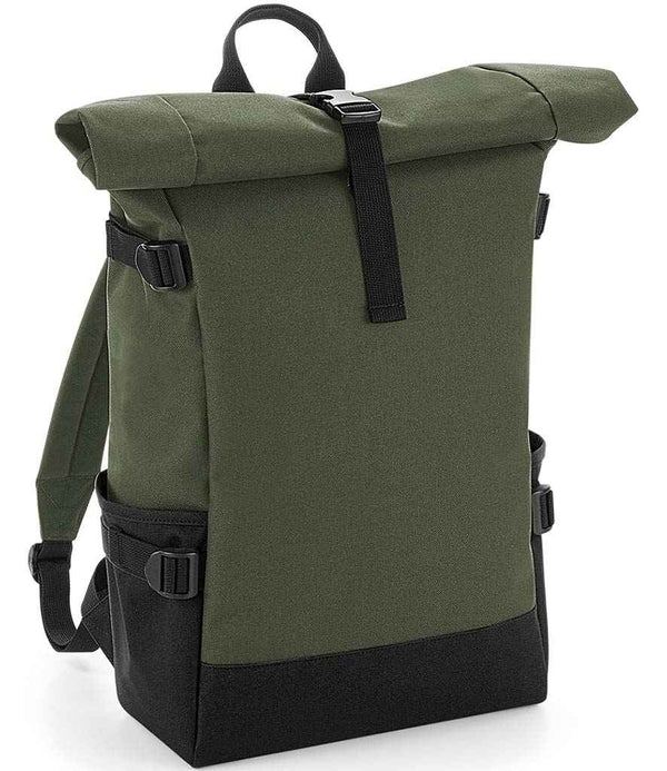The BagBase Block Roll-Top Backpack by BagBase is a green and black recycled polyester bag with side pockets, adjustable straps, top handle, front buckle closure, and padded laptop compartment. It stands upright on a plain background.