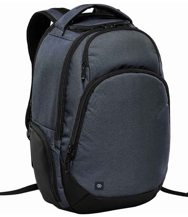 The Stormtech Madison Commuter Backpack, a dark gray 30L bag with multiple zippered compartments, a laptop sleeve, and padded shoulder straps by Stormtech, is displayed upright against a white background.