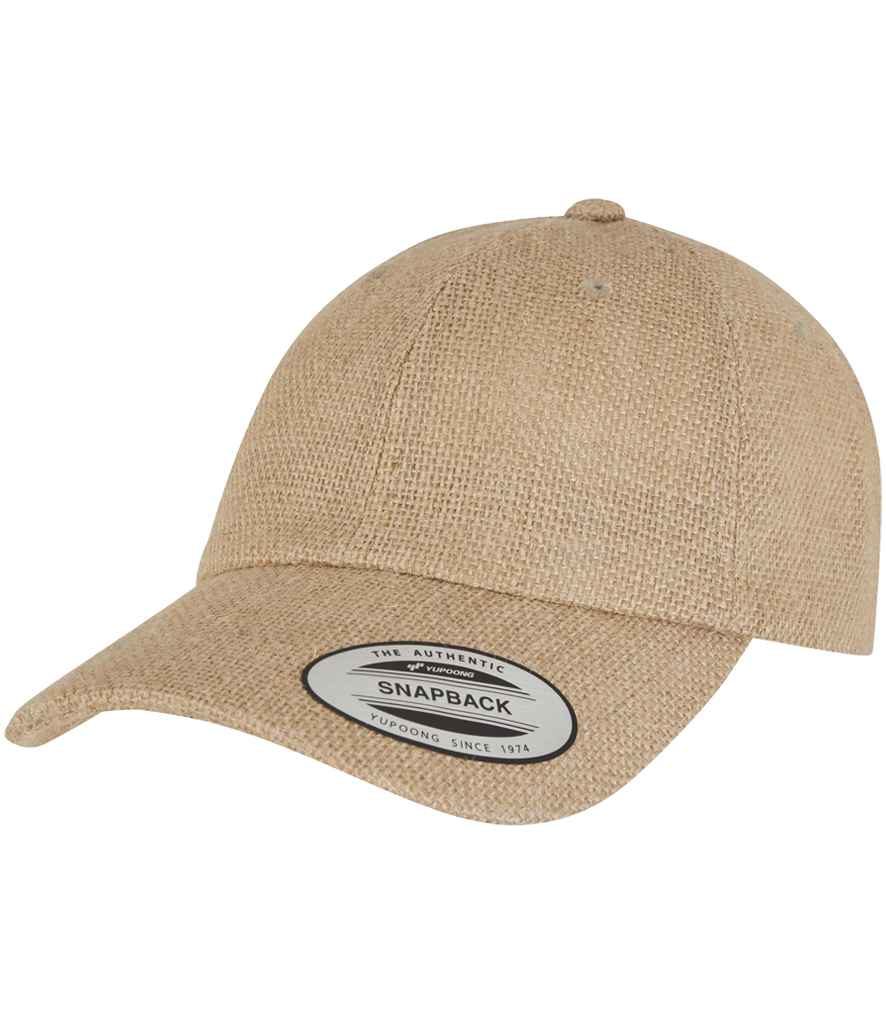 The Flexfit Dad Jute Cap by Flexfit is a beige textured jute weave cap with a curved brim, low profile design, and a SNAPBACK sticker on the bill.