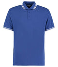 The Kustom Kit Contrast Tipped Poly/Cotton Piqué Polo Shirt is a blue short-sleeve classic fit shirt with a ribbed collar and sleeve cuffs featuring white double stripes, three-button placket, and plain front. Brand: Kustom Kit.