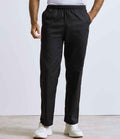 A person wears Premier Essential Chefs Trousers by Premier, featuring an elasticated waistband, with a white shirt and sneakers. Only the lower half of the body is shown against a plain, light background.
