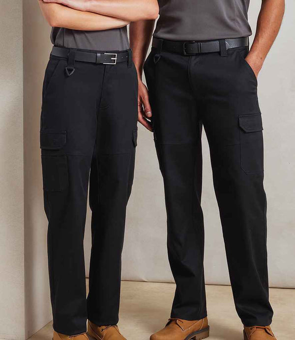 Two people stand side by side, each wearing Premier Unisex Stretchchecker Work Cargo Trousers with black belts, gray shirts, and tan work boots. Their upper bodies are partly out of frame against a plain, light-colored background.