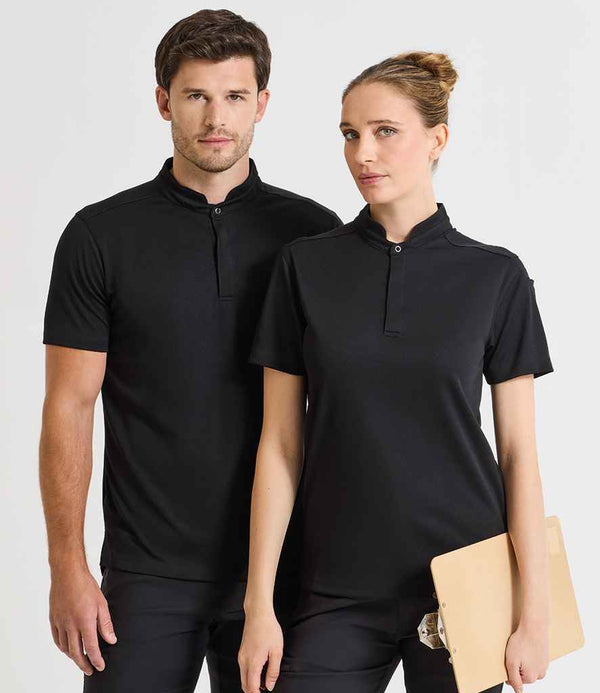 A man and a woman stand side by side, both wearing Premier Essential Coolchecker® Short Sleeve Chefs Shirts by Premier with mandarin collars. The woman holds a tan clipboard; both face forward against a plain light background.
