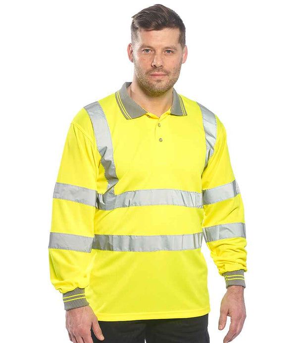 A man faces forward wearing the Portwest Hi-Vis Long Sleeve Polo Shirt by Portwest, a class 3 workwear featuring bright yellow fabric and reflective silver stripes on the chest, arms, and waist for high visibility.
