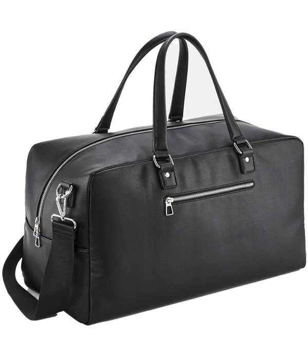 The Quadra Tailored Luxe Weekender by Quadra is a black leather duffel with silver zippers, two handles, and an adjustable shoulder strap. Made from recycled polyester, it has a zip front pocket and a roomy 25L main compartment.