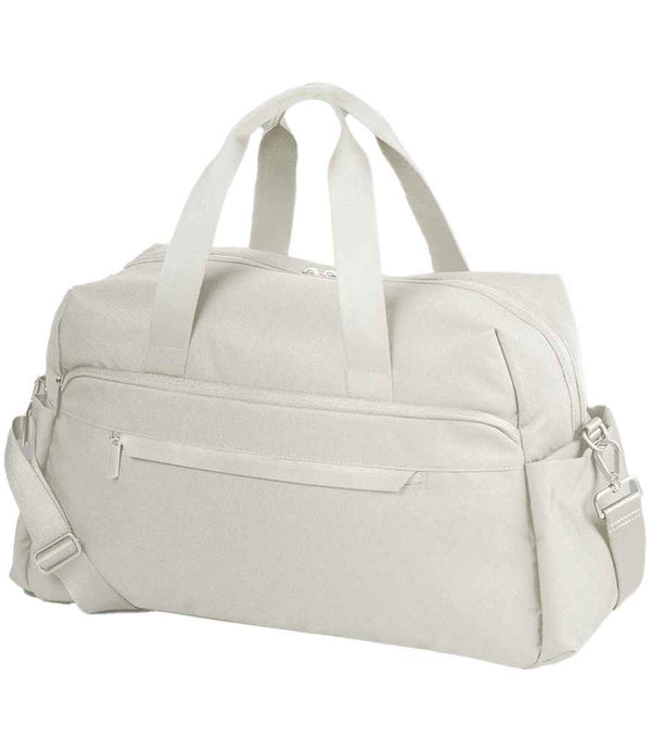 The Quadra Airside Weekender by Quadra is a light beige travel duffle with two short handles, an adjustable shoulder strap, roomy main compartment, front zippered pocket, and is airline overhead cabin compatible—shown on a white background.