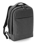 The Quadra Q-Tech Charge Convertible Backpack by Quadra is a grey laptop backpack with two main zippered compartments, a front zip pocket, padded shoulder straps, and a carrying handle, shown against a white background.