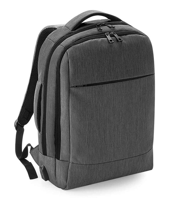 The Quadra Q-Tech Charge Convertible Backpack by Quadra is a grey laptop backpack with two main zippered compartments, a front zip pocket, padded shoulder straps, and a carrying handle, shown against a white background.