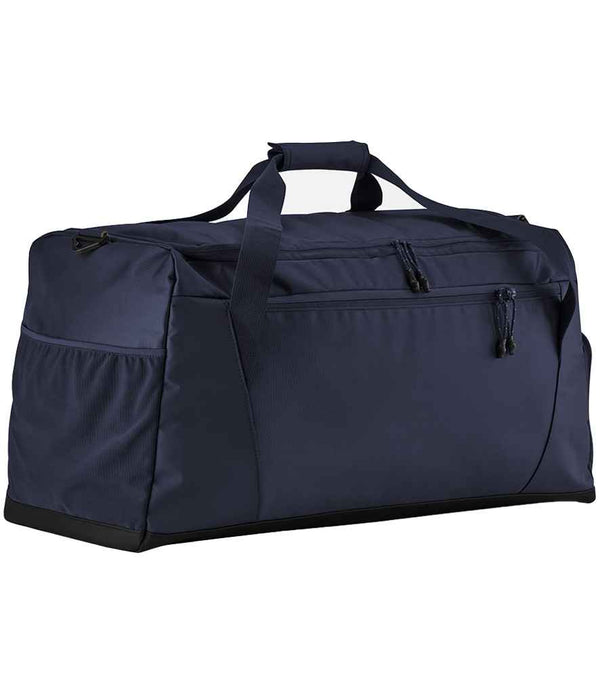 The Quadra Multi-Sport Holdall by Quadra is a large navy blue duffel bag with black zippers, shoe tunnel, side pockets, carrying handles, and a shoulder strap, shown on a plain white background.