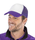 A man with light facial hair smiles while wearing the Result Core 1/2 Mesh Truckers Cap by Result Headwear, featuring a white and purple design with a recycled PE peak, paired with a purple shirt with a black collar.