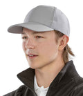 A young person wears the Result Recycled Low Profile Cap and a dark zip-up jacket over a white collared shirt, shown from the shoulders up against a plain white background.