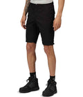 A person wearing a gray t-shirt, Regatta Pro Cargo Shorts by Regatta Professional, black socks, and black hiking shoes stands against a white background with their hands relaxed at their sides.