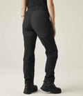 The lower half of a person is shown from behind, wearing Regatta Professional Regatta Ladies Prolite Stretch Trousers and black hiking boots against a plain light background.