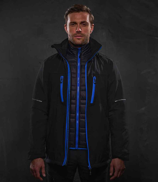 A man faces forward wearing the Regatta X-Pro Evader III 3-in-1 Jacket by Regatta Professional, a black waterproof coat with blue zippers and trim over a black recycled polyester padded layer, set against a plain dark background.