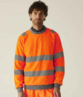 A man wearing a Regatta High Visibility Pro Contract Crew Neck Sweatshirt with gray reflective stripes, compliant with EN ISO 20471, stands facing forward against a plain light background.