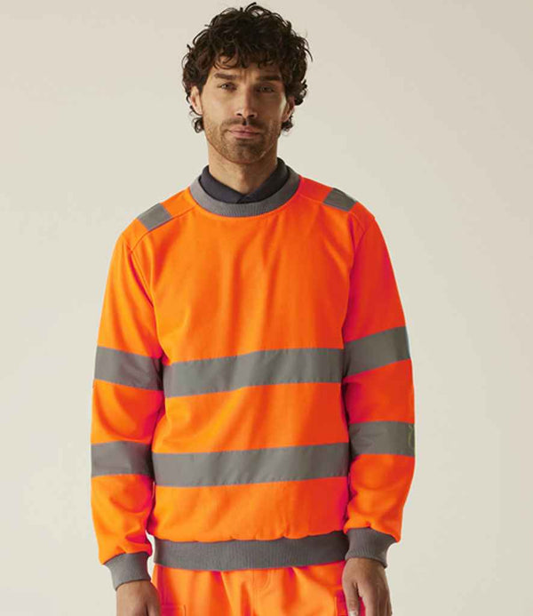A man wearing a Regatta High Visibility Pro Contract Crew Neck Sweatshirt with gray reflective stripes, compliant with EN ISO 20471, stands facing forward against a plain light background.