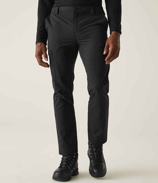 A person models the Regatta Pro Action Stretch Trousers by Regatta Professional, paired with a long-sleeve black shirt and boots. Cropped at the upper chest, the image focuses on the lower body against a plain light background.