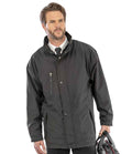 A man with short brown hair and a beard wears a Result City Executive Jacket by Result over a white shirt and black tie. He holds a motorcycle helmet in his left hand, standing against a plain white background.