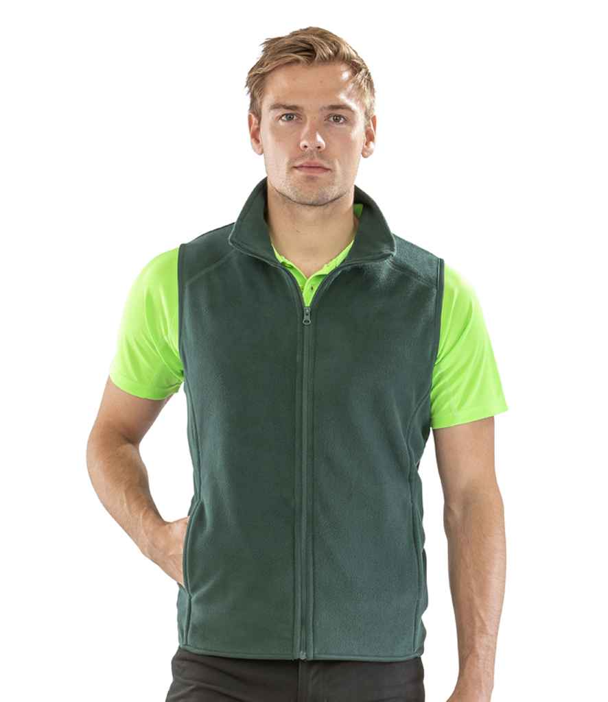 A person faces forward, wearing the Result Core Micro Fleece Gilet in green from Result Core over a bright green short-sleeve polo and black pants, with one hand in the gilet pocket.
