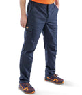 A person wearing Result Work-Guard Stretch Trousers by Result Work-Guard, featuring a reinforced hem, pairs them with an orange shirt and orange/navy sneakers. Only the lower body is visible against a white background, hands in pockets.