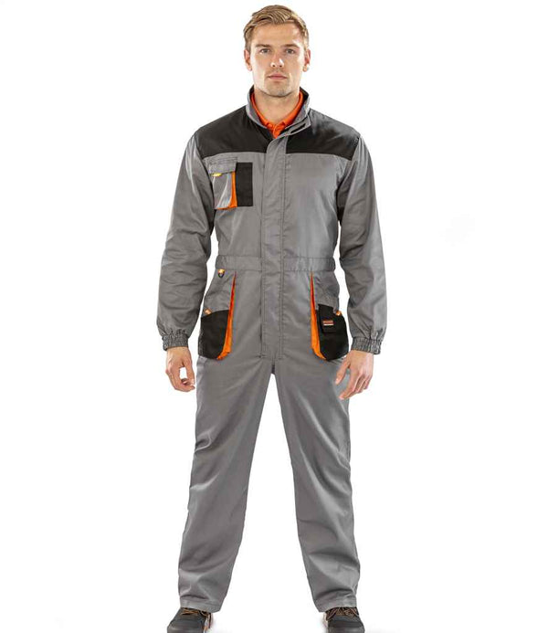 A person stands facing forward wearing the Result Work-Guard Lite Coverall by Result Work-Guard in gray with black and orange accents, featuring multiple cargo pockets and a zipper front. The background is plain white.