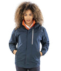 A person with curly hair wears the Result Work-Guard Denim Texture Rugged Jacket—a dark blue, breathable, windproof jacket with zipper, hood, side pockets, and white chest pocket detailing—against a plain white background.