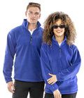 A man and a woman wearing Result Polartherm™ Zip Neck Fleece pullovers with sunglasses stand side by side against a white background.