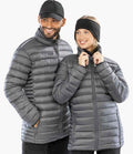 A smiling man and woman stand side by side in matching Result Recycled Padded Jackets from Result Recycled, both in light gray with recycled polyester padding. He wears a black cap; she has a black headband as they look to the side.
