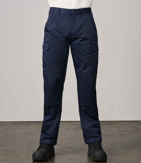 A person indoors wears Pro RTX Pro Workwear Cargo Trousers by Pro RTX, featuring knee pad pockets, with a white shirt tucked in and black shoes. The head is not visible; the background shows a concrete floor and light wall.