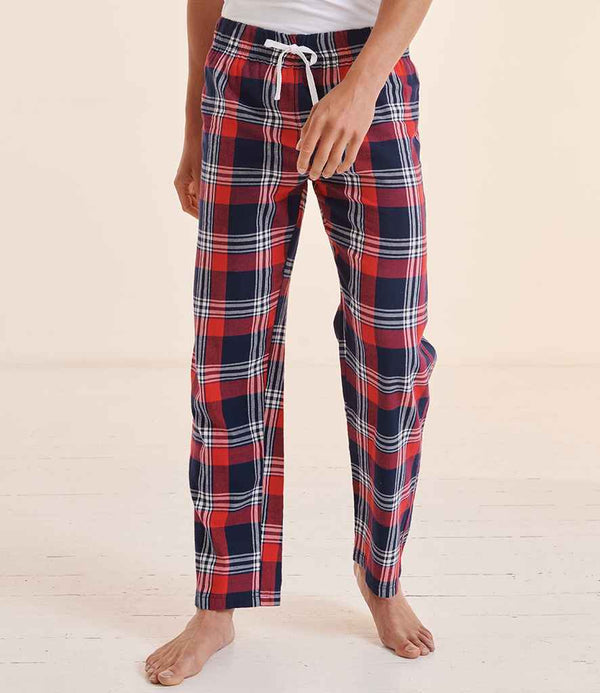 A person stands barefoot on a light floor, wearing SF Clothing Tartan Lounge Pants in red, navy blue, and white with an elastic waistband and white drawstring by SF Clothing. Their upper body is partially shown in a white top.