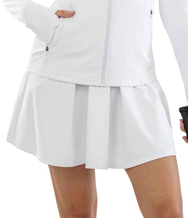Wearing the Spiro Ladies Recycled Fitness Skort, a person poses with one hand on their hip and the other holding a small black object. The photo, cropped from chest to mid-thigh, highlights the skorts full skirt span. Brand: Spiro.