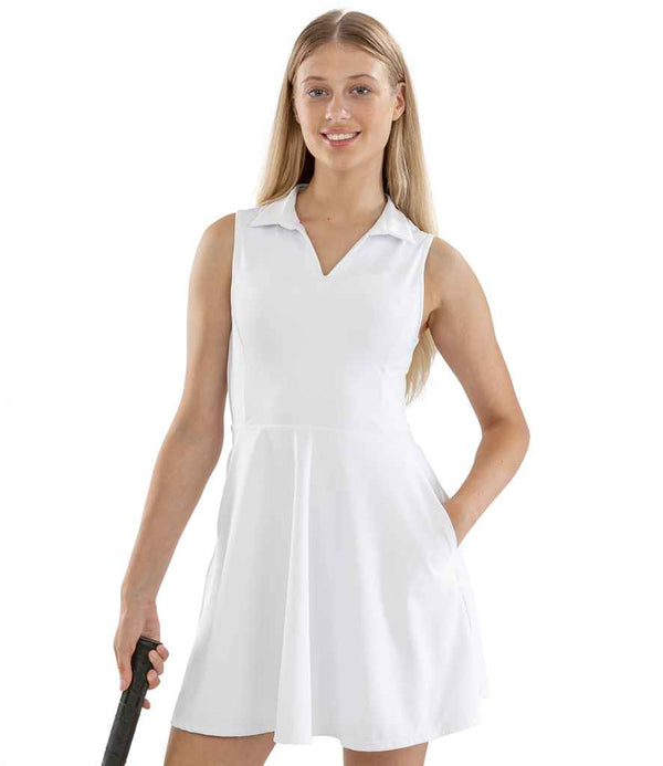 A woman with long blonde hair smiles at the camera while wearing the Spiro Ladies Recycled Fitness Dress by Spiro and holding a black paddle, against a plain white background.