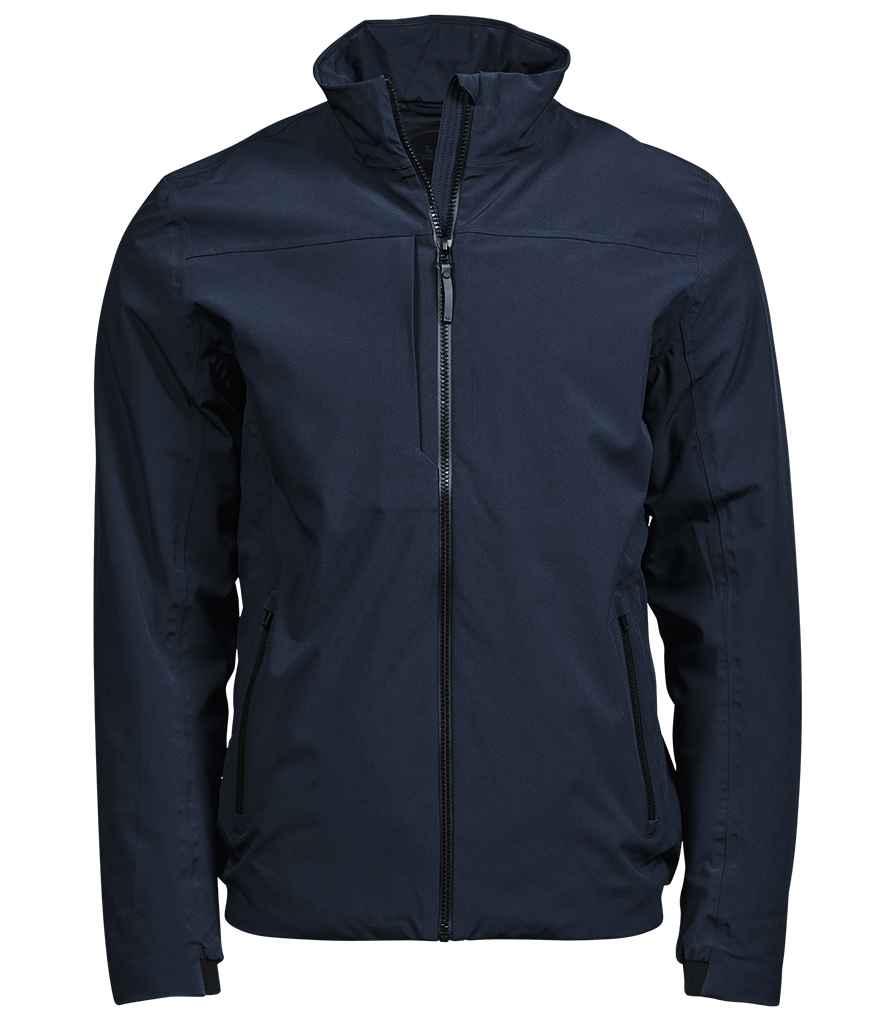 The Tee Jays All Weather Jacket by Tee Jays is a dark navy zip-up with a high collar, long sleeves, two side pockets, and a chest pocket with vertical zipper. Made from recycled polyester, this fitted jacket blends style and function.