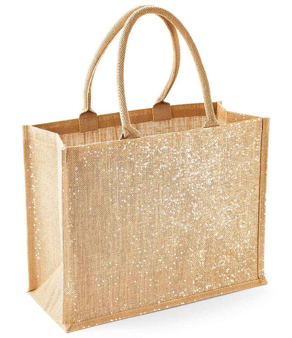 The Westford Mill Shimmer Jute Shopper is a tan rectangular tote bag with gold shimmer thread, sturdy cotton handles, a glittery white front, flat bottom, and a practical 21L capacity—stylish and durable from Westford Mill.