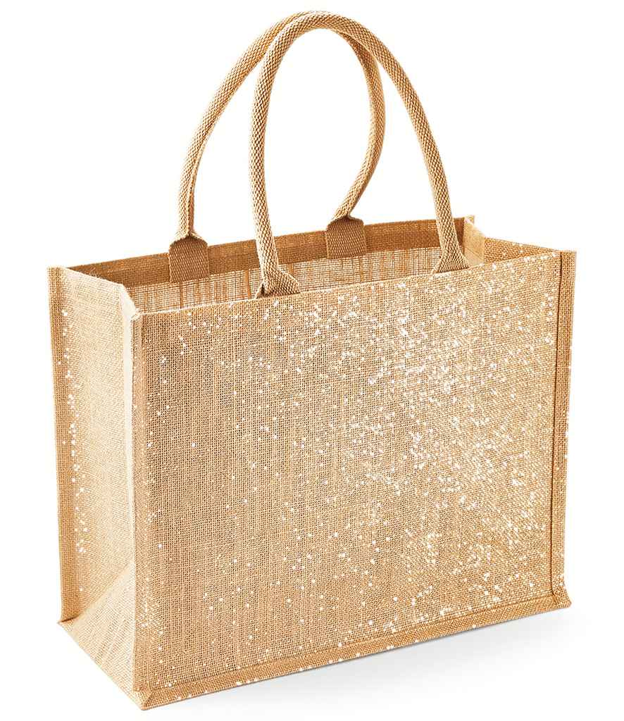 The Westford Mill Shimmer Jute Shopper is a tan rectangular tote bag with gold shimmer thread, sturdy cotton handles, a glittery white front, flat bottom, and a practical 21L capacity—stylish and durable from Westford Mill.