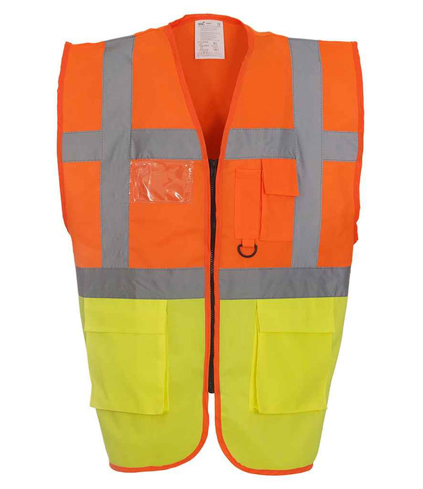 The Yoko Executive Waistcoat by YOKO features a high-visibility orange top, yellow bottom, EN ISO 20471 reflective stripes, front pockets, a clear ID holder, and a zipper closure. Shown against a white background.